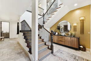 Stairway with stone finish flooring and recessed lighting