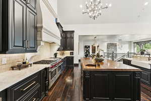 Kitchen featuring dark cabinetry, dark wood-type flooring, a center island, butcher block countertops, and recessed lighting