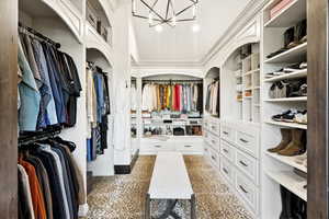 Walk in closet featuring a chandelier and granite tiled floors