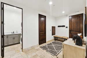 Bathroom with recessed lighting, vanity, washer / clothes dryer, and stone tile flooring