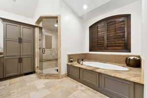 Full bathroom with a stall shower, a bath, vaulted ceiling, and recessed lighting
