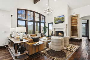 Living area with hardwood / wood-style flooring, arched walkways, plenty of natural light, and a high ceiling