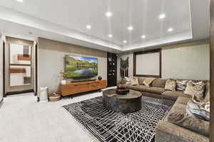 Cinema with recessed lighting, light colored carpet, and a tray ceiling