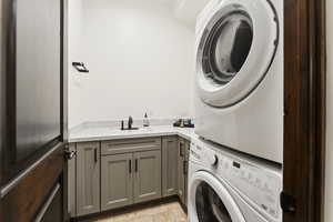 Laundry area with stacked washer and clothes dryer and cabinet space