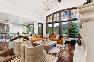 Living room featuring a chandelier, hardwood / wood-style flooring, a mountain view, high vaulted ceiling, and recessed lighting