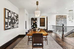 Dining space featuring a chandelier, hardwood / wood-style flooring, recessed lighting, and arched walkways