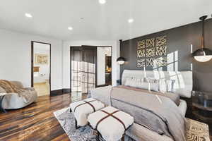 Bedroom featuring recessed lighting, wood finished floors, and connected bathroom
