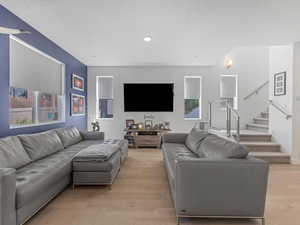 Living room featuring light wood-type flooring and stairway