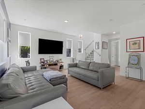 Living area with light wood-type flooring, stairs, and recessed lighting