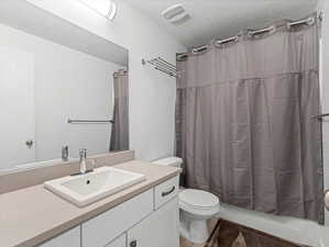 Bathroom with vanity, a textured ceiling, and shower / tub combo
