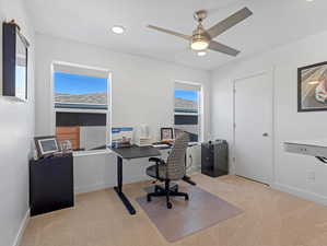 Carpeted home office with a ceiling fan and recessed lighting
