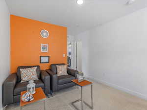 Carpeted living area with baseboards