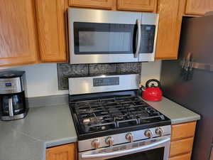 Kitchen featuring stainless steel appliances and light countertops