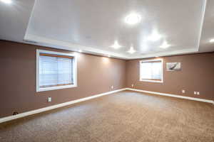 Unfurnished room with a tray ceiling and carpet