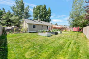 Fenced backyard featuring a garden and a storage unit