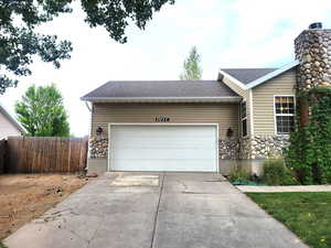 Single story home with stone siding, concrete driveway, a garage, and roof with shingles