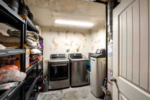 Laundry room featuring washer and clothes dryer and water heater