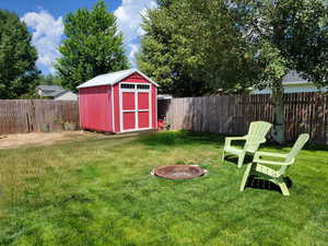 Fenced backyard featuring a shed