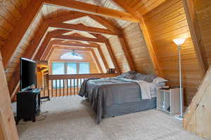 Carpeted bedroom with wooden walls and wood ceiling