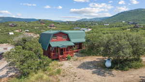 View of front of house featuring a gambrel roof, a metal roof, a mountain view, and covered porch