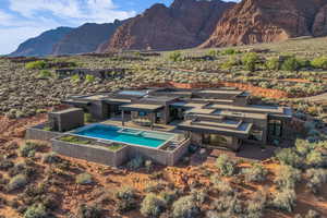 Back of property with an outdoor pool, a mountain view, and a patio