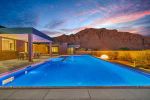 View of pool with a patio, a pool with connected hot tub, and a mountain view