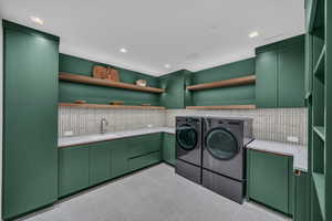 Laundry area featuring washer and clothes dryer and cabinet space