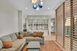 Living room with recessed lighting, a chandelier, and wood finished floors