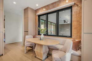Dining room with light wood finished floors and recessed lighting