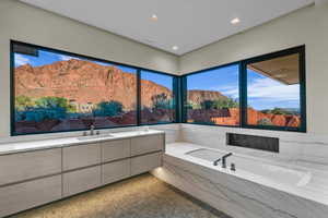 Bathroom featuring a bath, a mountain view, and recessed lighting