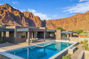 View of swimming pool featuring a mountain view, a patio area, a pool with connected hot tub, and ceiling fan