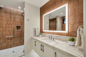 Full bath with vanity, a stall shower, recessed lighting, and tile walls