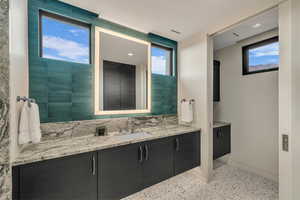 Bathroom with speckle patterned floor and vanity