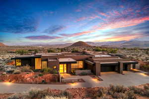 Pueblo-style house featuring a mountain view, stucco siding, and a garage