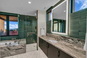 Full bath featuring vanity, a bath, a stall shower, and recessed lighting
