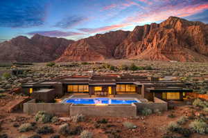 Back of house featuring a patio area, a mountain view, an outdoor pool, and stucco siding
