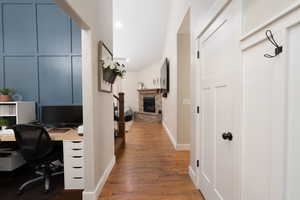 Entry with wood finished floors, a fireplace, and lofted ceiling