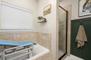Full bath featuring a shower stall and a bath
