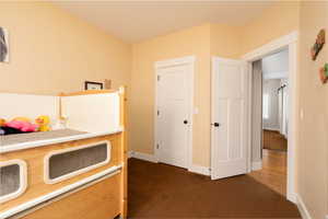 Bedroom with dark colored carpet and baseboards