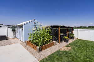 View of chicken coop with a garden and a fenced backyard