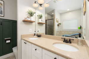 Bathroom with a stall shower, double vanity, and tile patterned floors