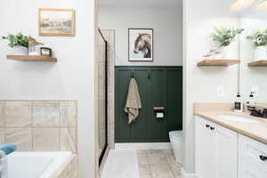 Bathroom with vanity, a garden tub, tiled shower, and tile patterned floors
