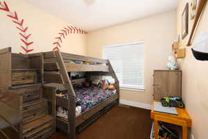 Bedroom featuring carpet and baseboards