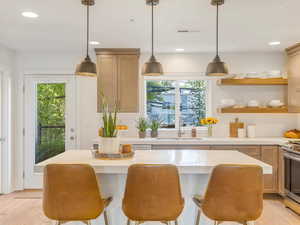 Kitchen featuring tasteful backsplash, light wood finished floors, plenty of natural light, recessed lighting, and light countertops