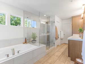 Full bathroom with a garden tub, a stall shower, vanity, and tile patterned floors