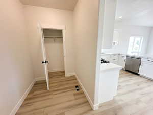 Corridor featuring light wood-style floors and recessed lighting