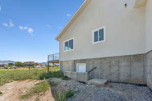 View of home's exterior with stucco siding and a balcony