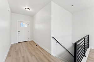 Foyer featuring light wood-type flooring and baseboards