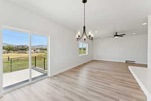 Unfurnished room featuring ceiling fan, light wood-style flooring, a chandelier, recessed lighting, and a baseboard heating unit