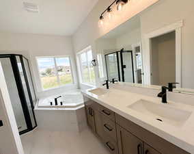 Full bath featuring a shower stall, a garden tub, double vanity, and light marble finish floors